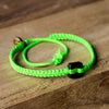 Black Raymi Bright Green bracelets that fight poverty on wood