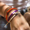 White Tinkus Violet Purple donation bracelets on wrist
