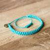 Andel Bright Cyan Knotted Charity Bracelet on wood