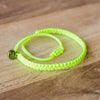 Andel Electric Yellow Knotted Charity Bracelet on wood