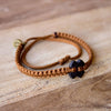 Black Tinkus Sweet Caramel donation bracelets on wood