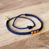 Brown Chasqui Dark Blue bracelets that help children on wood