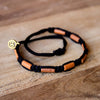 Brown Sisa Carbon Black tribal macrame bracelets on wood