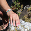 White Chasqui Bright Cyan bracelets that help children on wrist