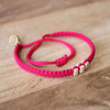 White Chasqui Candy Pink bracelets that help children on wood