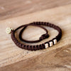 White Chasqui Chocolate Brown bracelets that help children on wood