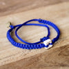 White Raymi Electric Blue bracelets that fight poverty on wood