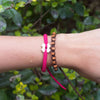 White Tinkus Strawberry Pink donation bracelets on wrist