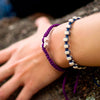 White Tinkus Violet Purple donation bracelets on wrist
